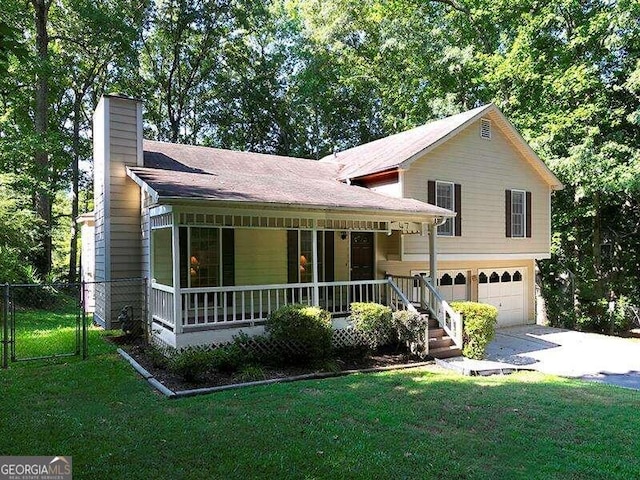 split level home featuring a porch, a garage, and a front lawn