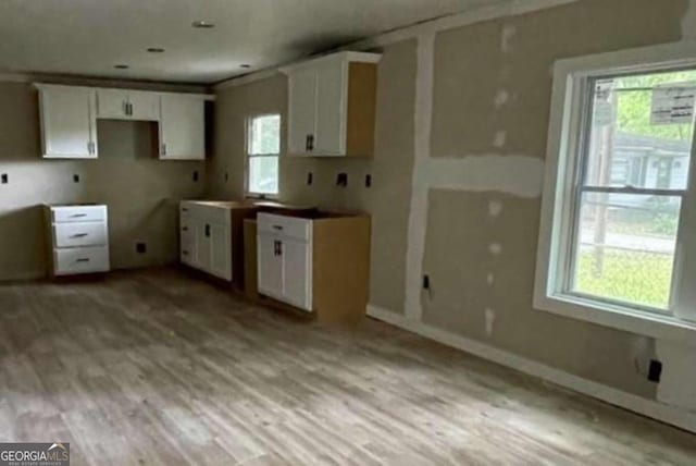 kitchen with light hardwood / wood-style flooring and white cabinetry