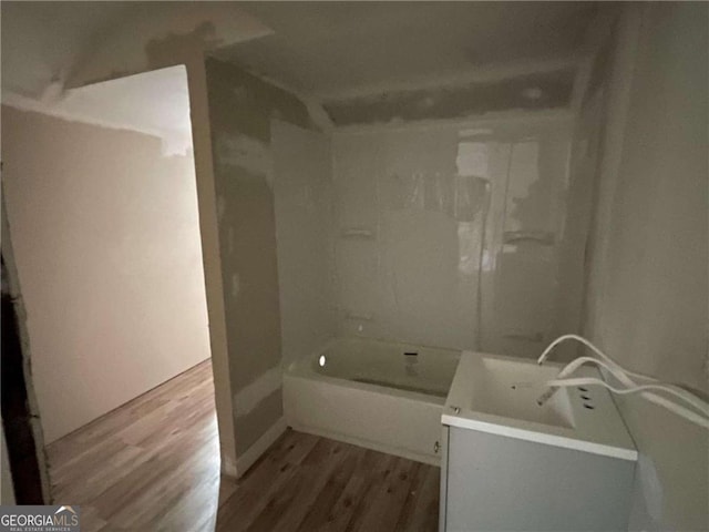 bathroom with wood-type flooring,  shower combination, and vanity