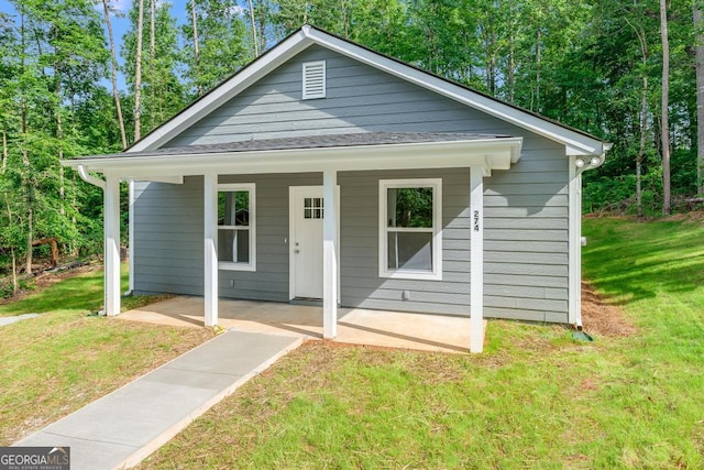 bungalow-style house featuring covered porch and a front yard