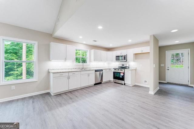 kitchen featuring light hardwood / wood-style flooring, stainless steel appliances, sink, and white cabinets