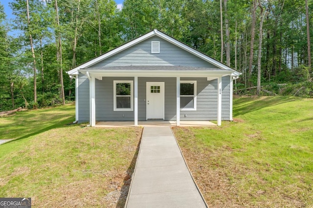 bungalow-style home with a front yard and covered porch