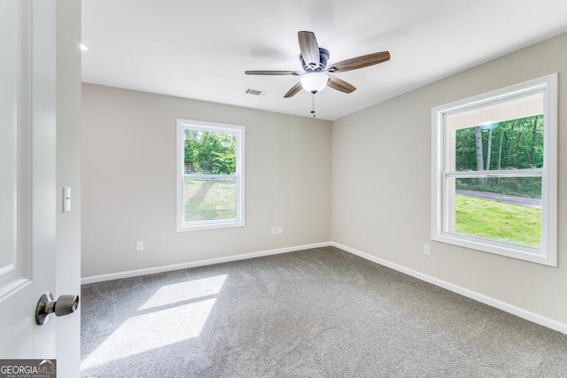 carpeted spare room with a healthy amount of sunlight and ceiling fan