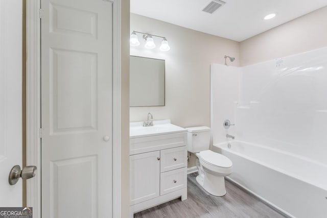 full bathroom featuring vanity, toilet, hardwood / wood-style flooring, and shower / bathing tub combination