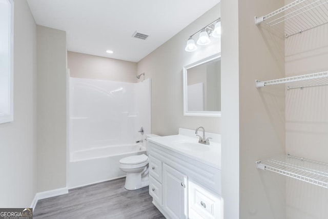 full bathroom with vanity, toilet, wood-type flooring, and  shower combination