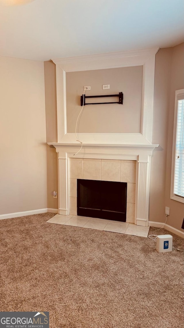 room details featuring a tile fireplace and carpet