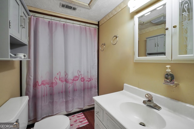 bathroom with hardwood / wood-style floors, toilet, a shower with curtain, vanity, and a textured ceiling