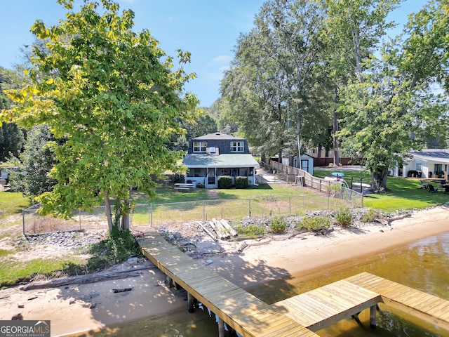 view of dock featuring a water view and a yard