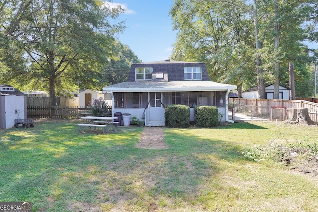 back of property featuring a lawn, a storage unit, and a sunroom