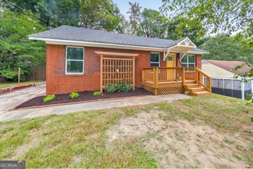 ranch-style house with a deck and a front yard