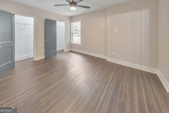 empty room with dark wood-type flooring and ceiling fan