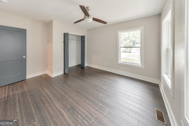 unfurnished bedroom featuring dark wood-type flooring, ceiling fan, and a closet