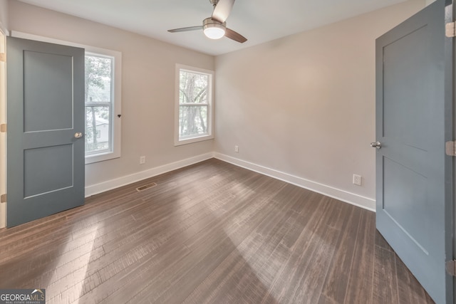 unfurnished room with dark hardwood / wood-style flooring and ceiling fan