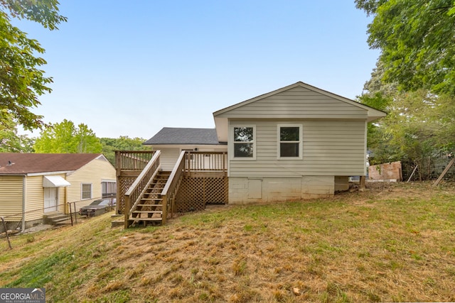 rear view of property featuring a yard and a deck