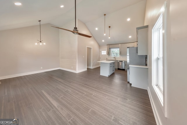 interior space with high vaulted ceiling, dishwasher, a center island, ceiling fan, and dark hardwood / wood-style floors