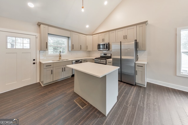 kitchen featuring dark hardwood / wood-style floors, appliances with stainless steel finishes, a center island, sink, and gray cabinets