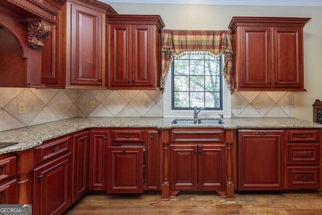 kitchen with sink, hardwood / wood-style floors, and backsplash