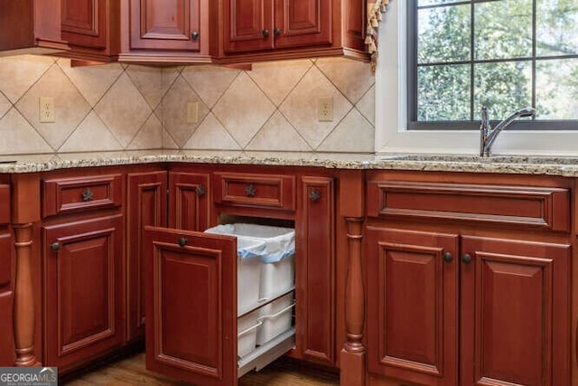 kitchen with light stone countertops, tasteful backsplash, and a sink