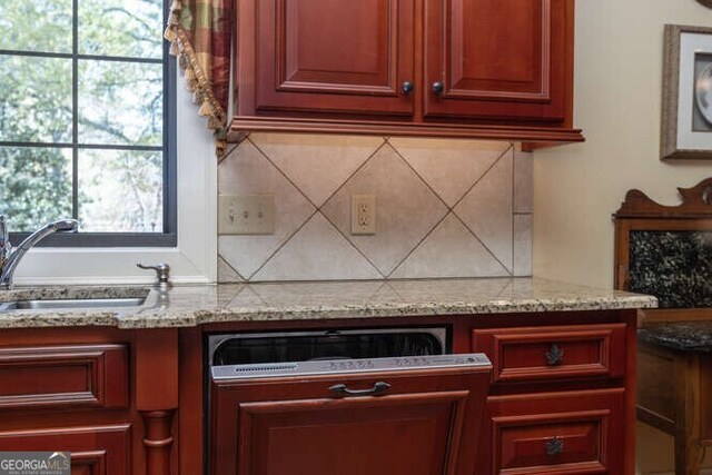 kitchen with plenty of natural light, sink, and light stone countertops