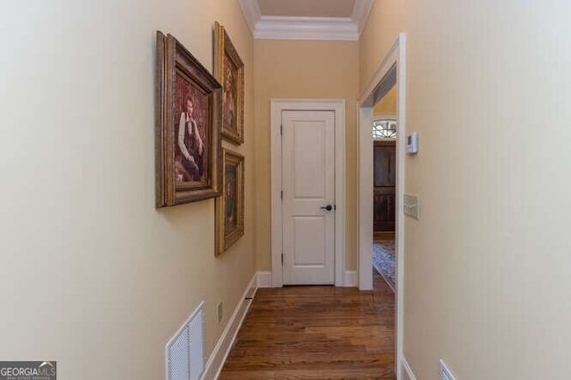 corridor featuring ornamental molding and dark wood-type flooring