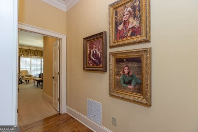 corridor with hardwood / wood-style flooring and crown molding