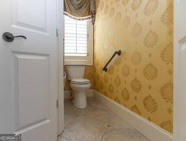 bathroom with toilet and tile patterned floors