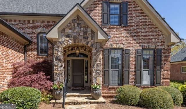 property entrance with brick siding and stone siding