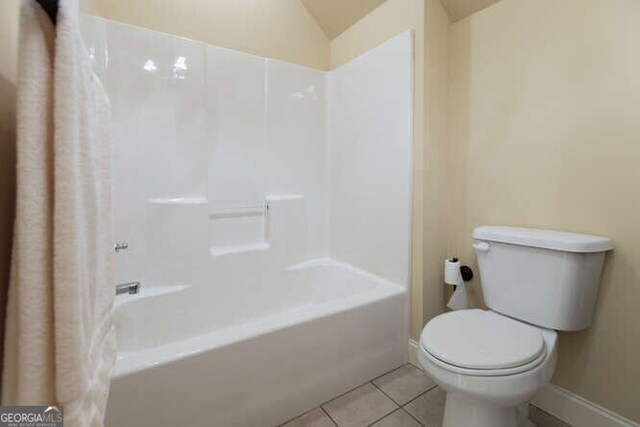 bathroom featuring vaulted ceiling, toilet, tile patterned floors, and shower / bath combo