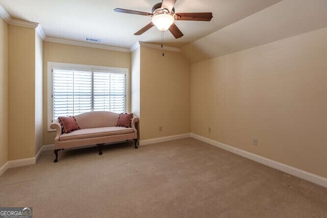 living area with lofted ceiling, crown molding, ceiling fan, and light colored carpet