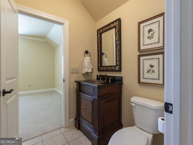 half bathroom with tile patterned floors, toilet, baseboards, vanity, and vaulted ceiling