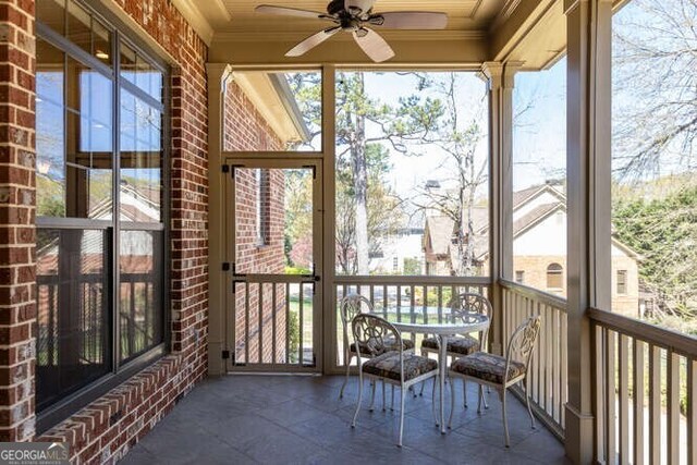 unfurnished sunroom featuring a healthy amount of sunlight and ceiling fan