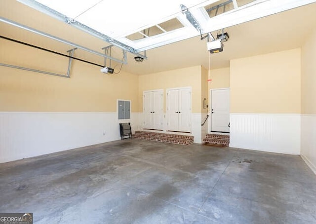 garage with a garage door opener and wainscoting