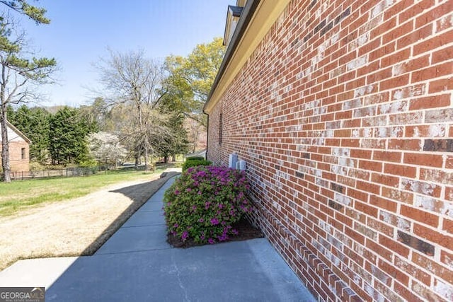 view of home's exterior featuring fence and brick siding