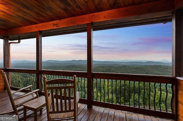 deck at dusk featuring a mountain view