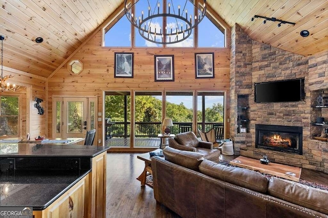 living room featuring wood walls, a notable chandelier, high vaulted ceiling, and dark hardwood / wood-style flooring