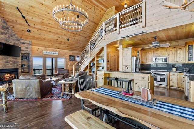 dining area featuring a fireplace, high vaulted ceiling, ceiling fan with notable chandelier, wooden ceiling, and hardwood / wood-style flooring