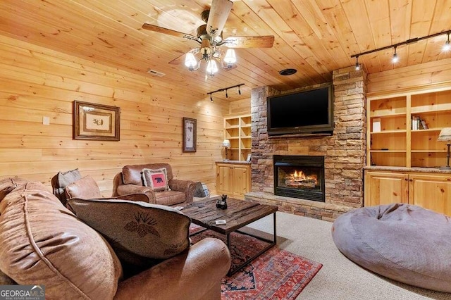 living room featuring a fireplace, carpet floors, wood ceiling, rail lighting, and ceiling fan