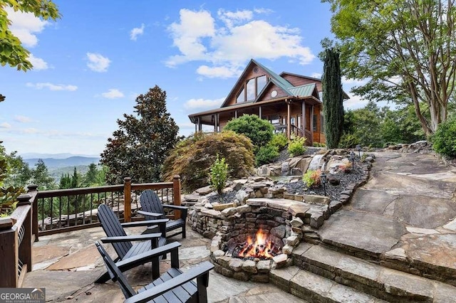 view of patio with a mountain view and an outdoor fire pit