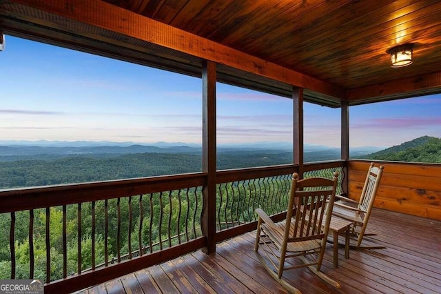 deck at dusk featuring a mountain view