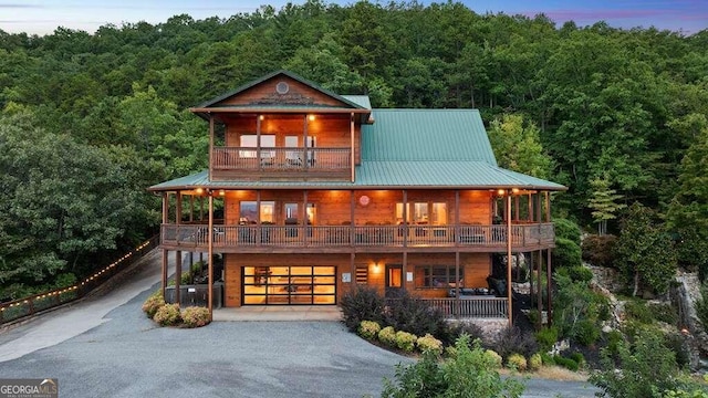 back house at dusk with a balcony