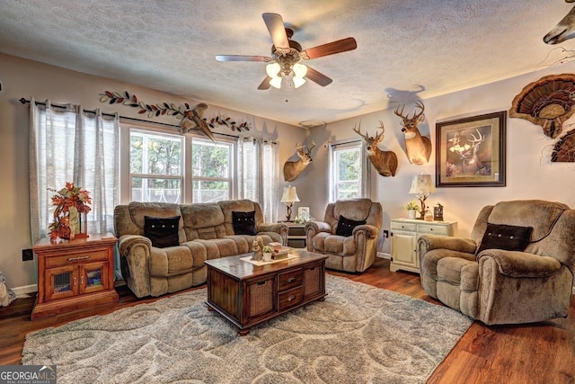 living room with a textured ceiling, ceiling fan, and hardwood / wood-style floors