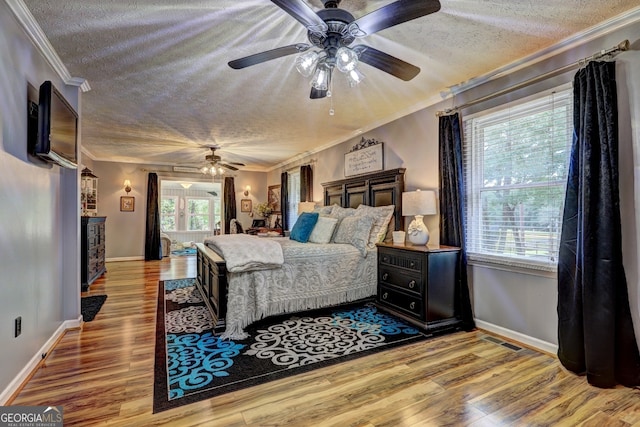 bedroom with ceiling fan, ornamental molding, a textured ceiling, and light hardwood / wood-style flooring