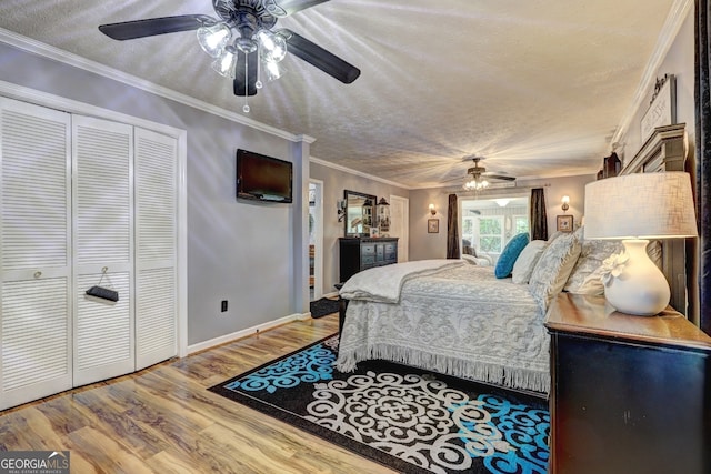 bedroom with crown molding, hardwood / wood-style floors, a closet, ceiling fan, and a textured ceiling