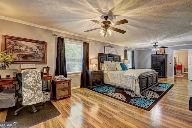 bedroom featuring a textured ceiling, crown molding, ceiling fan, and light wood-type flooring