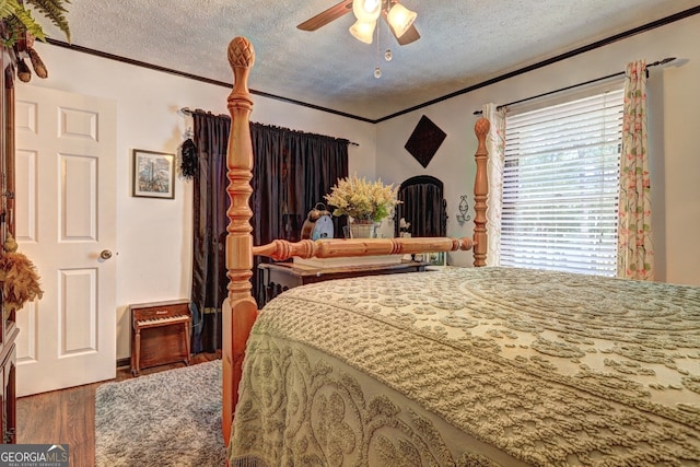 bedroom with a textured ceiling, crown molding, ceiling fan, and wood-type flooring