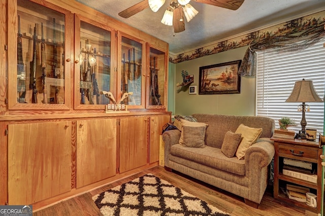 sitting room featuring a textured ceiling, hardwood / wood-style floors, and ceiling fan