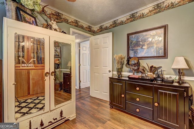 interior space with hardwood / wood-style flooring, crown molding, and a textured ceiling