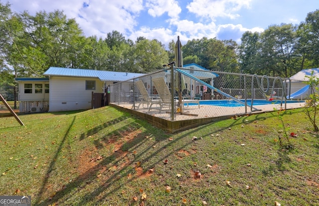 view of pool featuring a water slide and a lawn