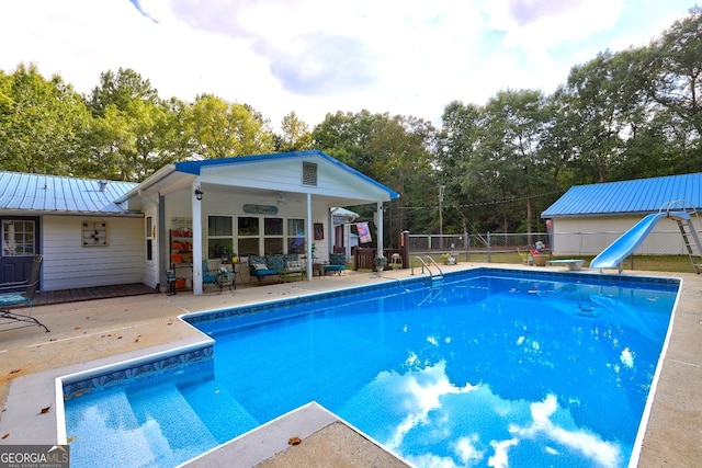 view of pool featuring a water slide, ceiling fan, and a patio