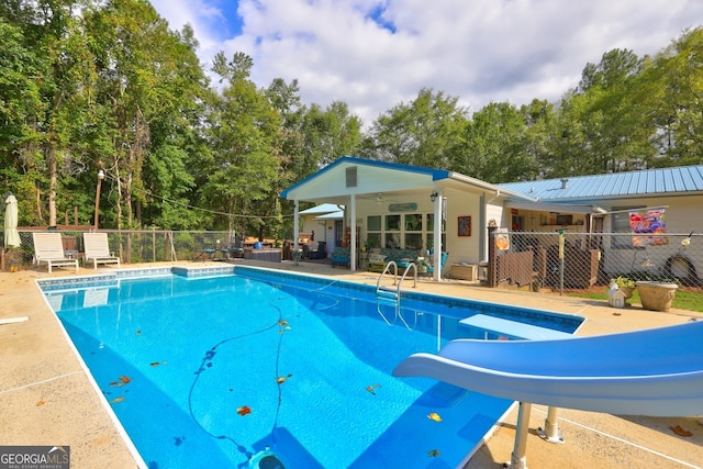 view of pool featuring a water slide, a patio area, and ceiling fan